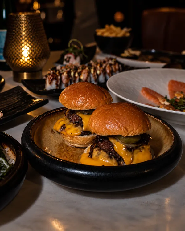 Mini-burgers met cheddar en gebakken ui bij kaarslicht