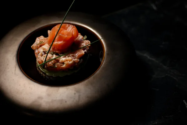 Zalmtartaar met een roosje van zalm en bieslook